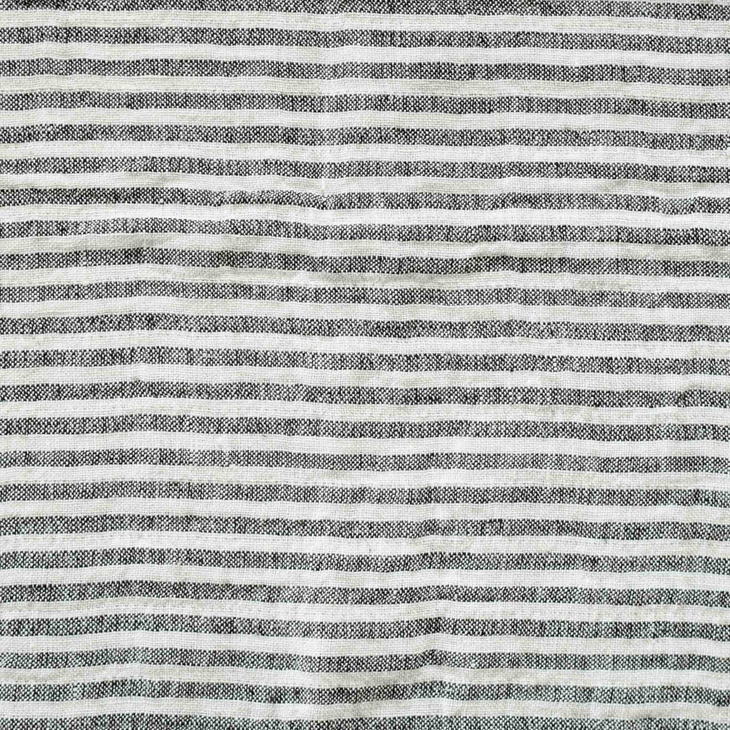 Black and white stripes with a decorative cushion with fringed edges add texture and style to the setting.