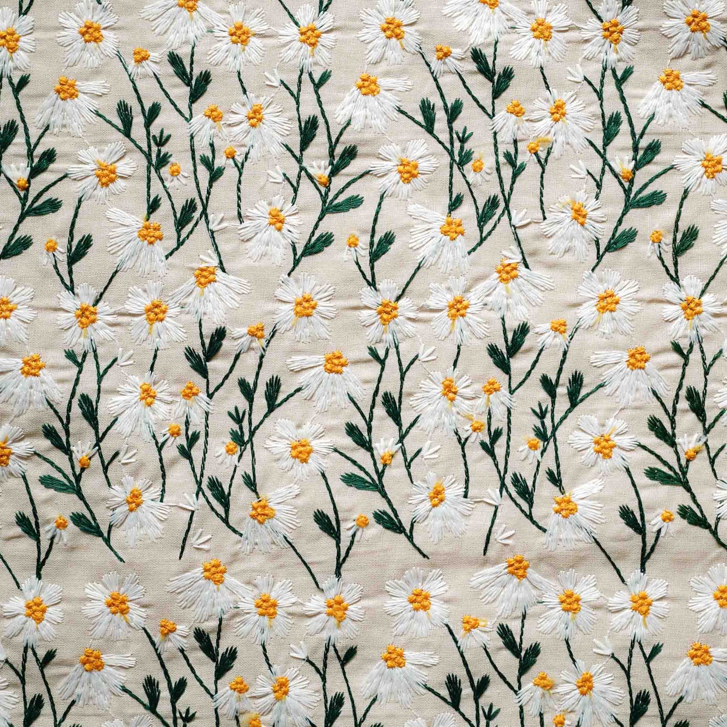 Tiny daisy pattern embroidered beige background cushion.
