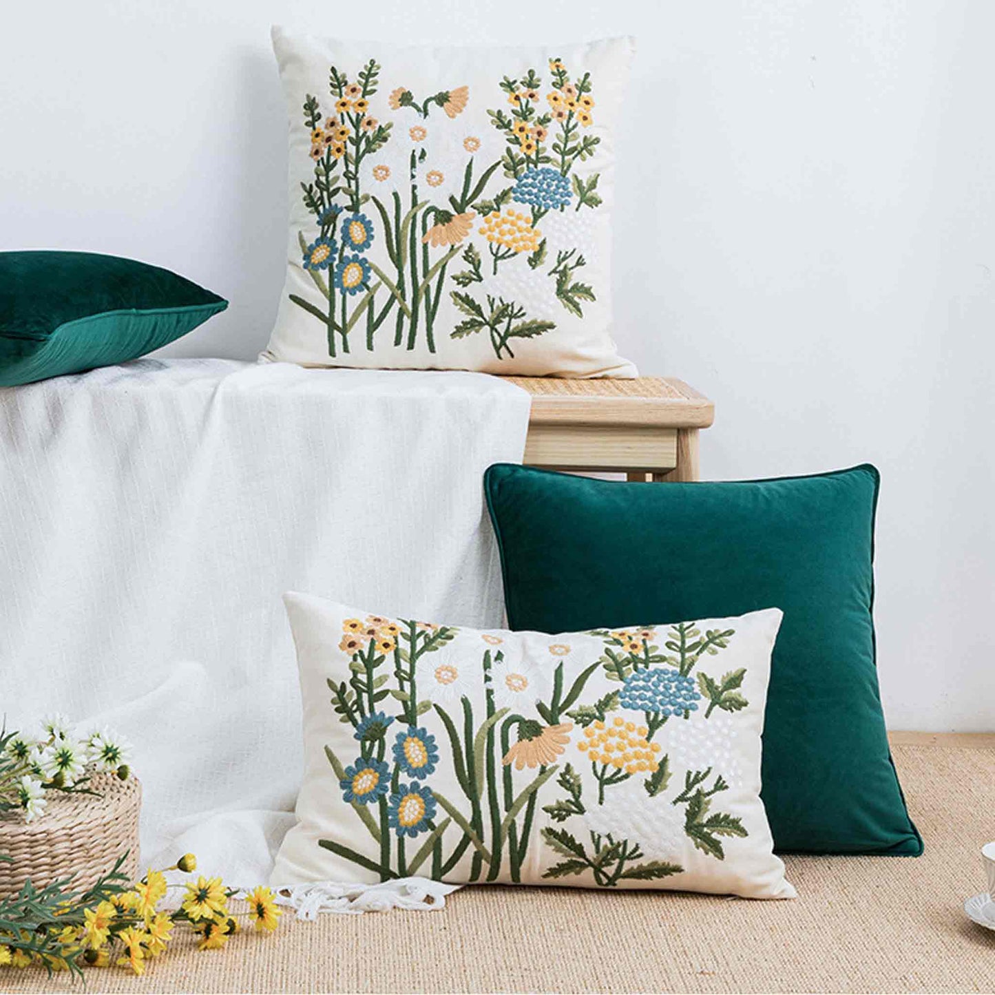 Decorative cushion cover with colorful embroidered floral pattern on a white background.