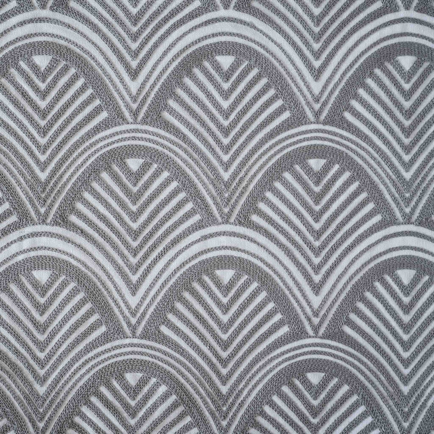 The grey and white scalloped embroidery patterned cushion shows off decorative design and texture.