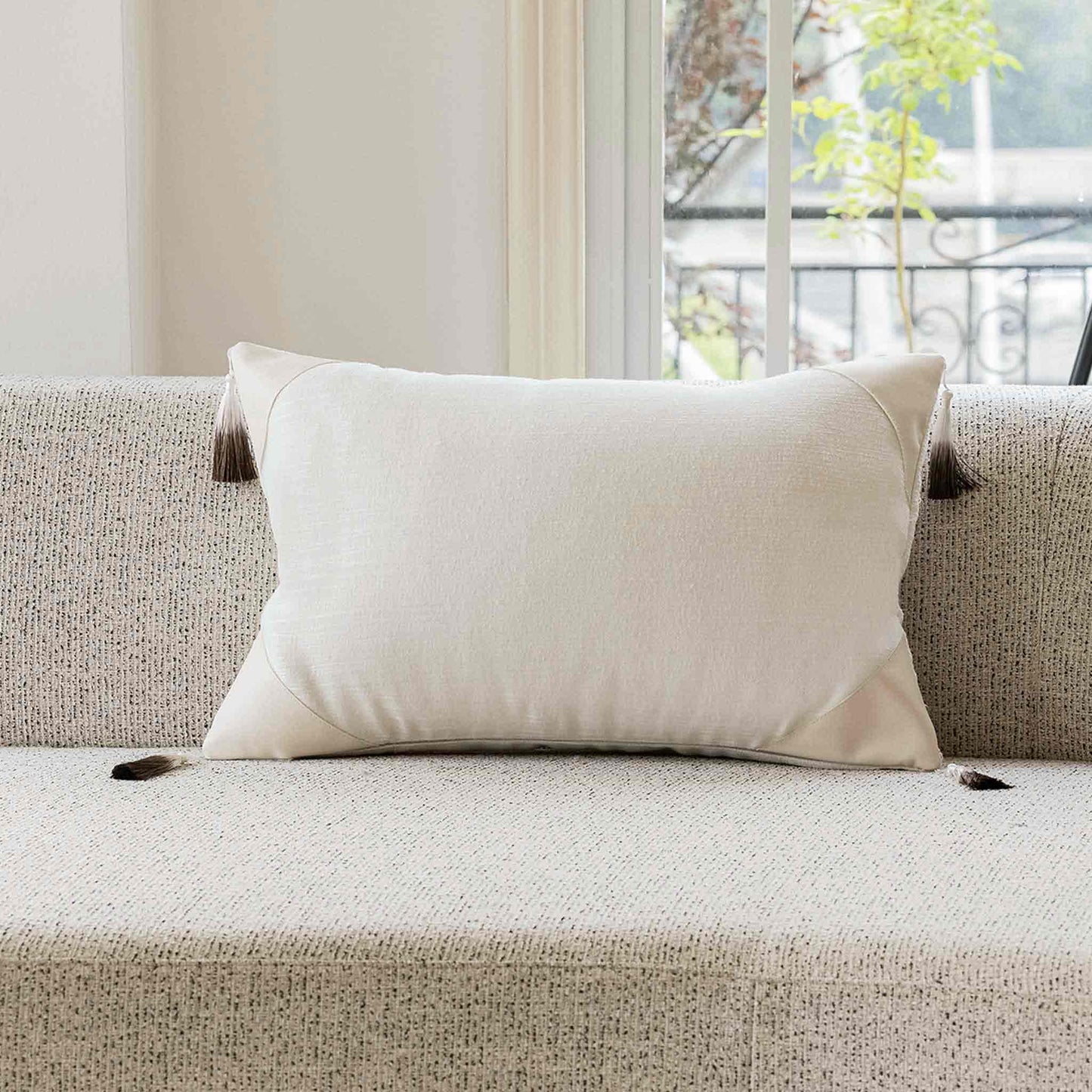 Natural white cotton patchwork PU with gradient tassels lumbar cushion cover on sofa.