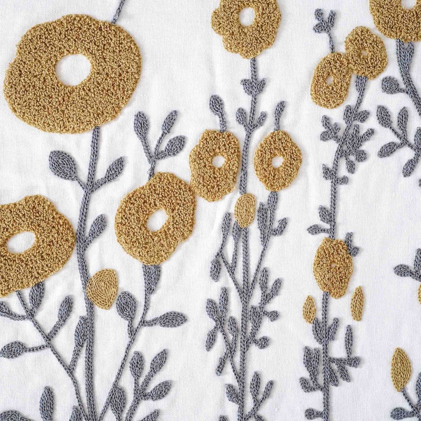 Tufted yellow flower cushion on white background.