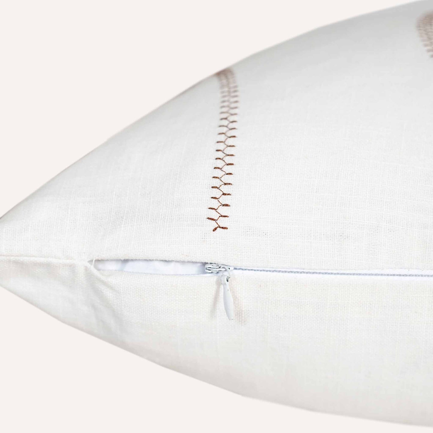 Close-up of the invisible zip on the ball stitch white background cushion.