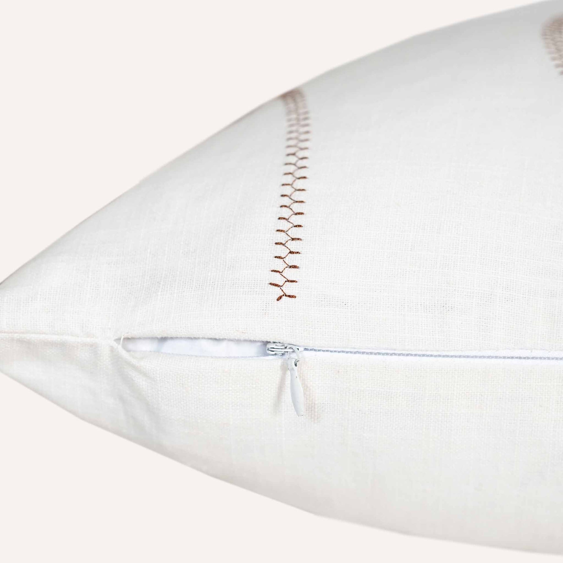 Close-up of the invisible zip on the ball stitch white background cushion.