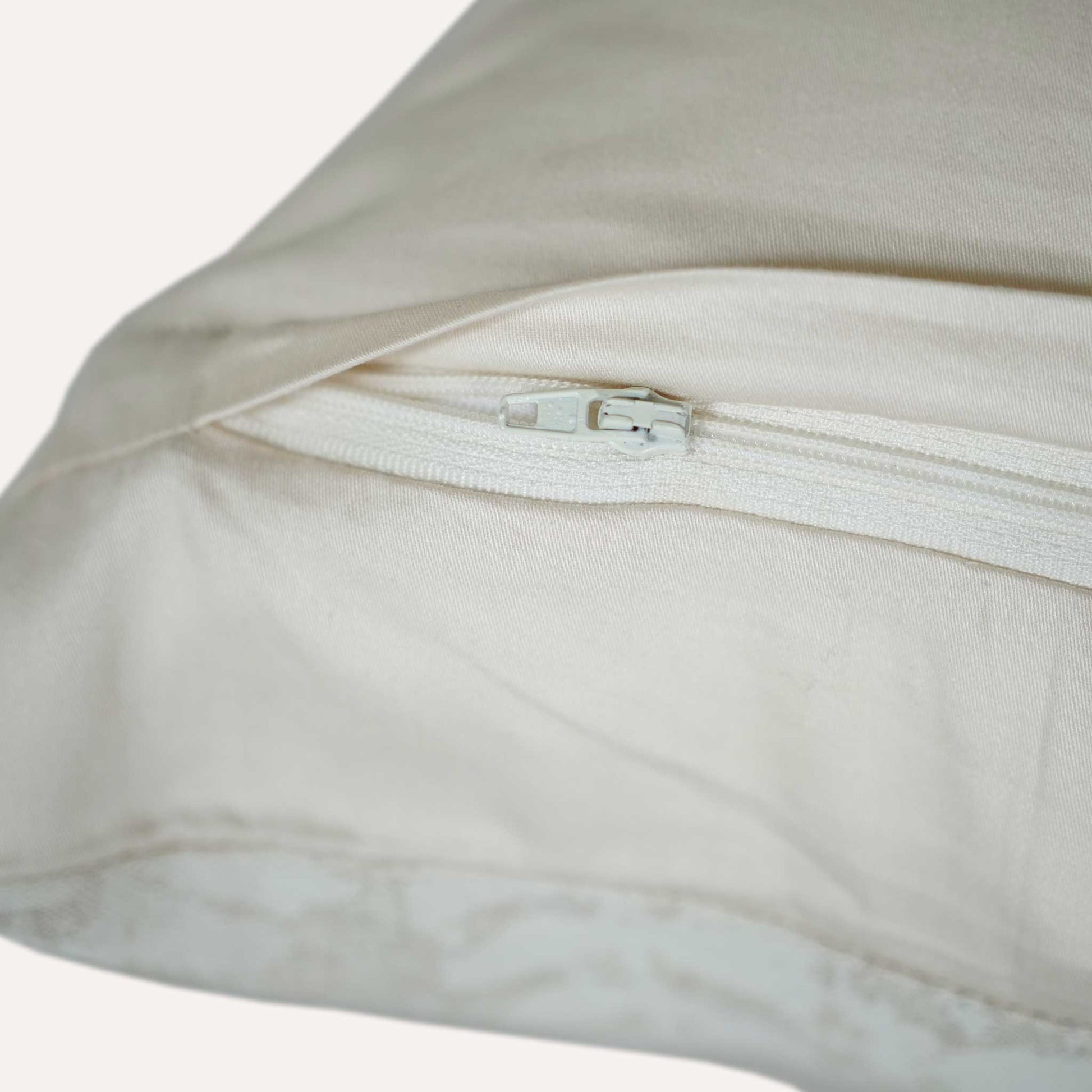 Close-up of a cushion featuring a visible zipper along one edge, showcasing its design and functionality.