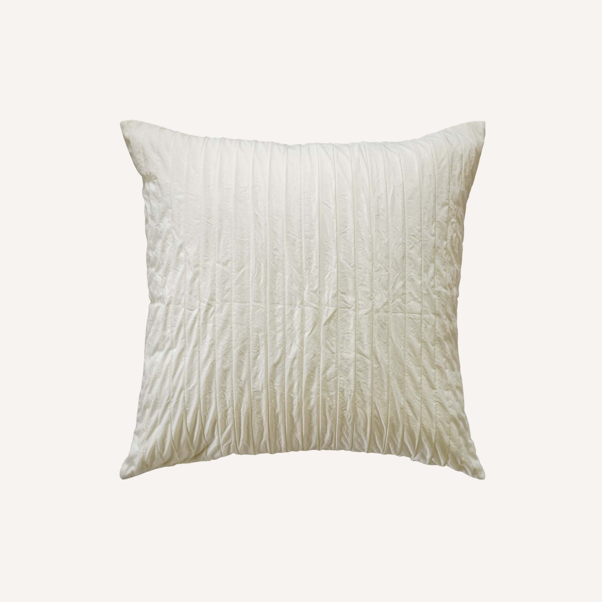 A white cushion with an elegant pleated design adds texture and style to any bedding arrangement.