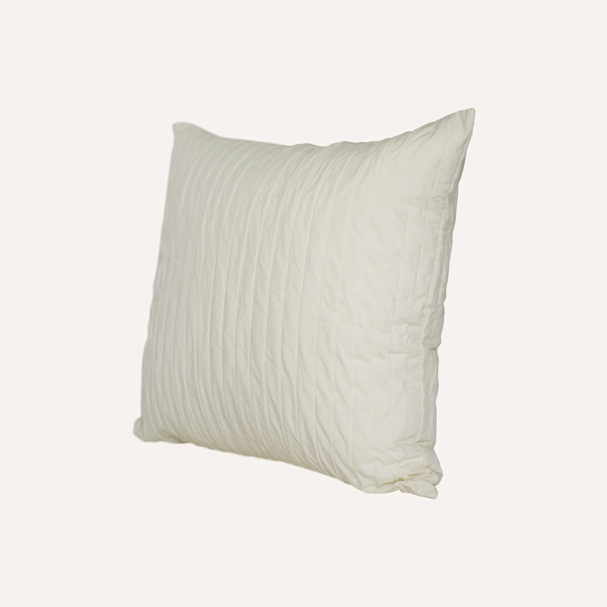 A white cushion with an elegant pleated design adds texture and style to any bedding arrangement.