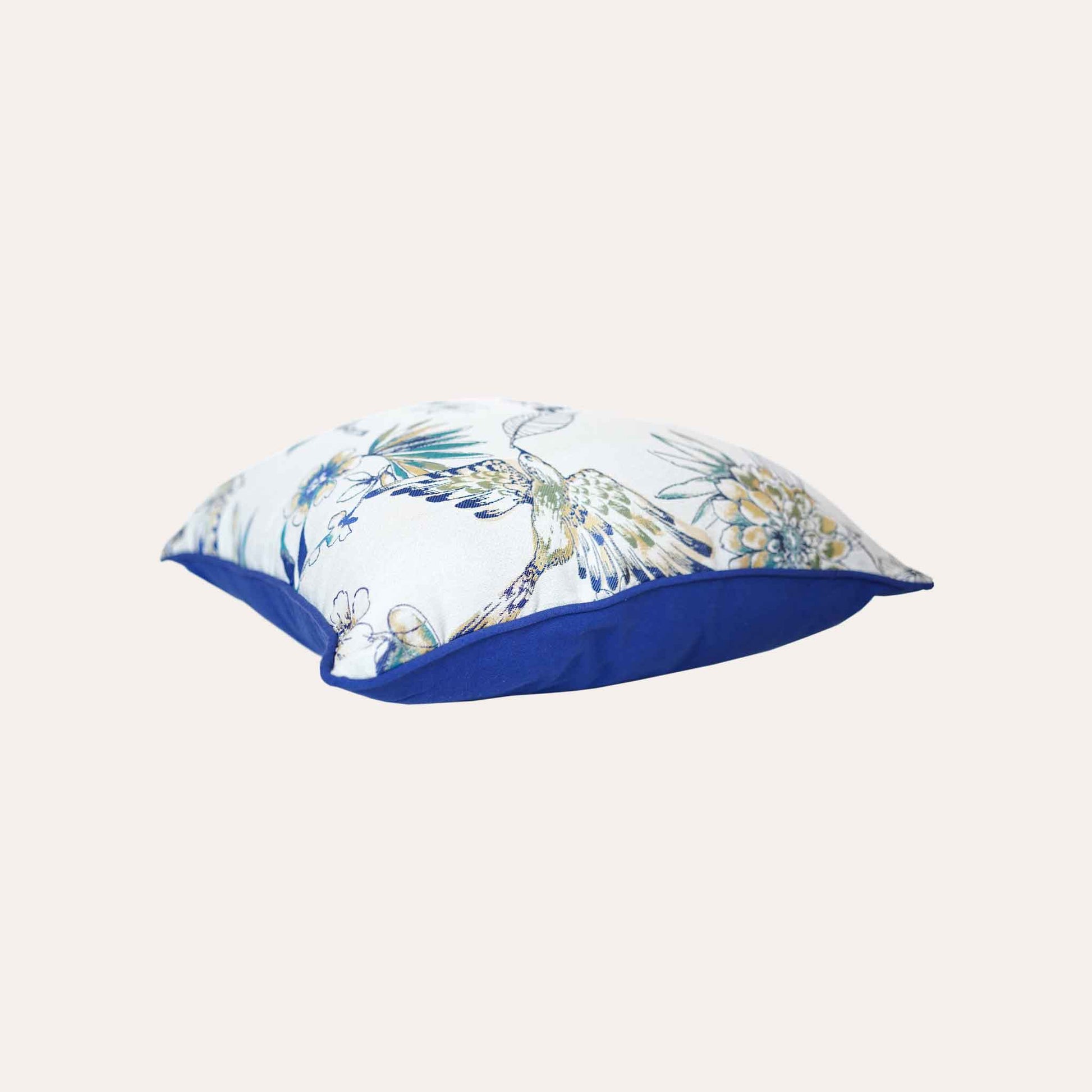A charming white and blue cushion showcasing beautiful bird and floral patterns.