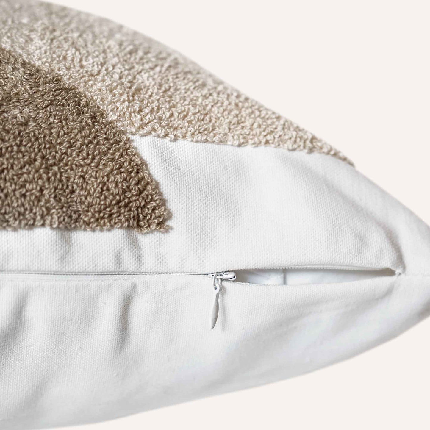 Close-up of the invisible zip on the black beige tufted cushion.