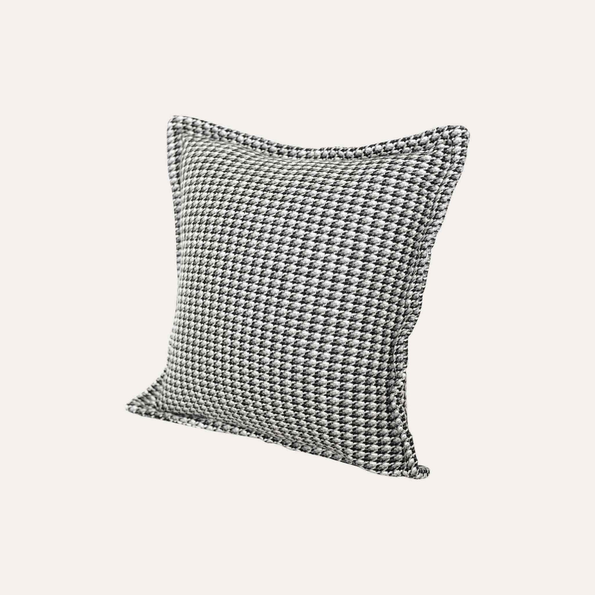 A black and grey checkered cushion cover featuring a houndstooth pattern with wide edges.