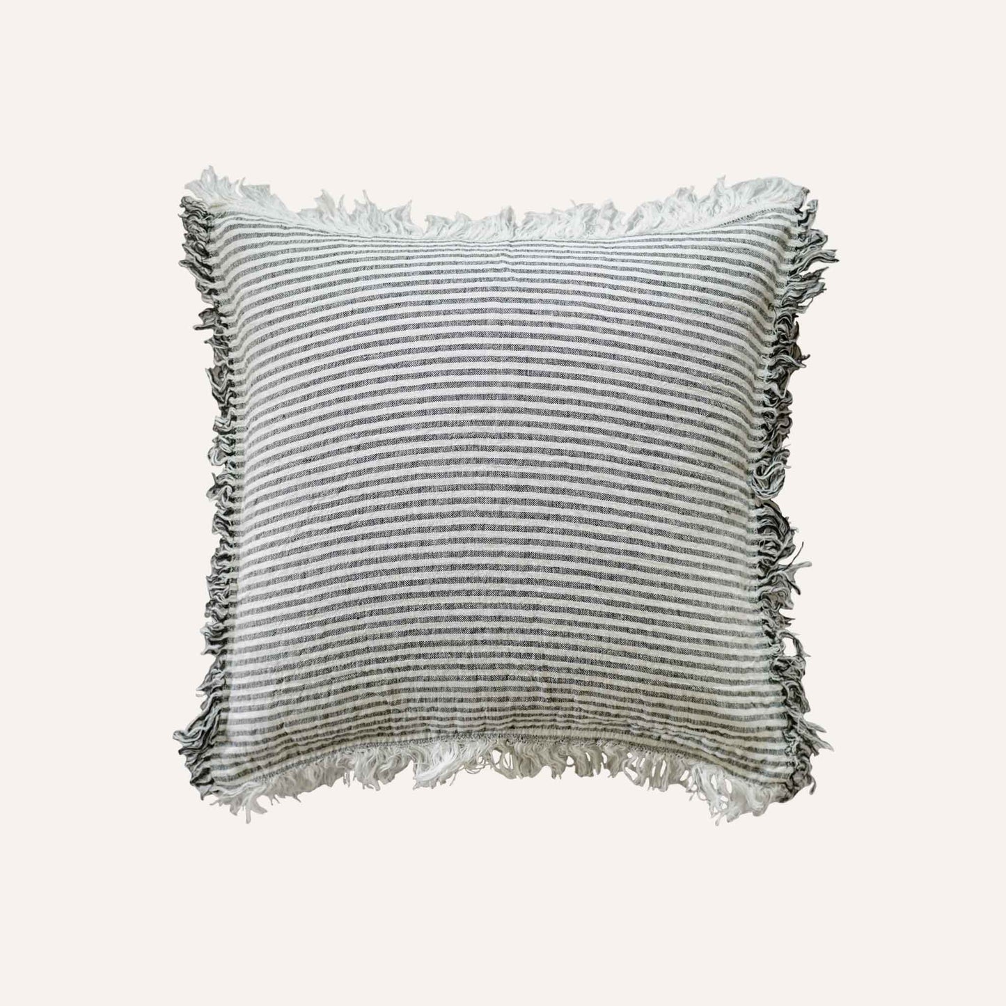 Black and white stripes with a decorative cushion with fringed edges add texture and style to the setting.