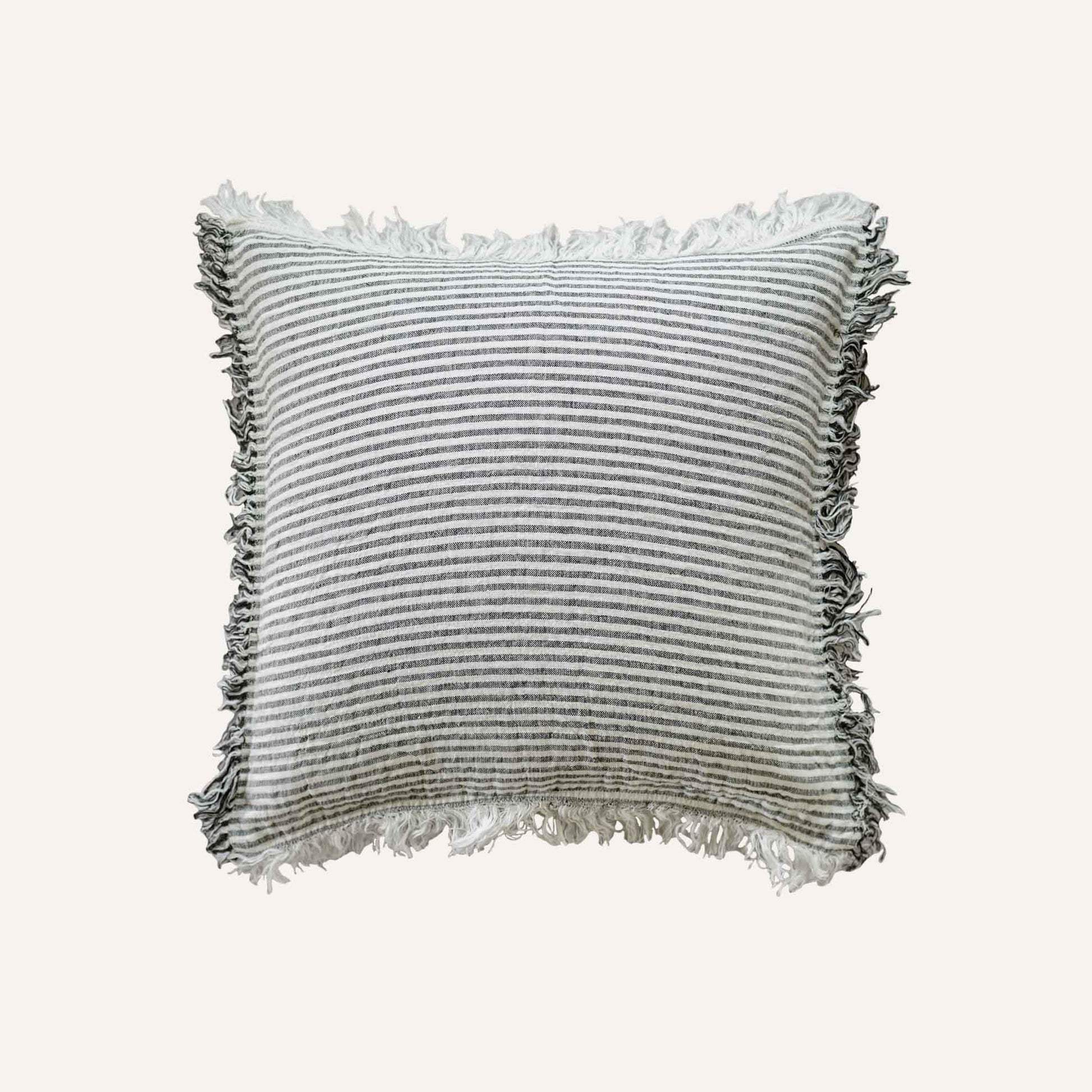 Black and white stripes with a decorative cushion with fringed edges add texture and style to the setting.