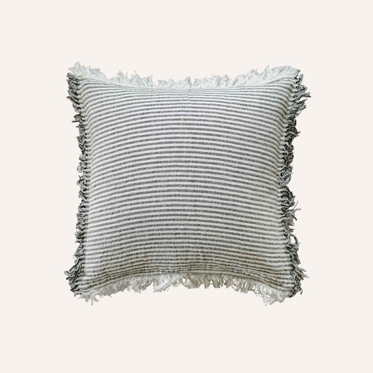 Black and white stripes with a decorative cushion with fringed edges add texture and style to the setting.