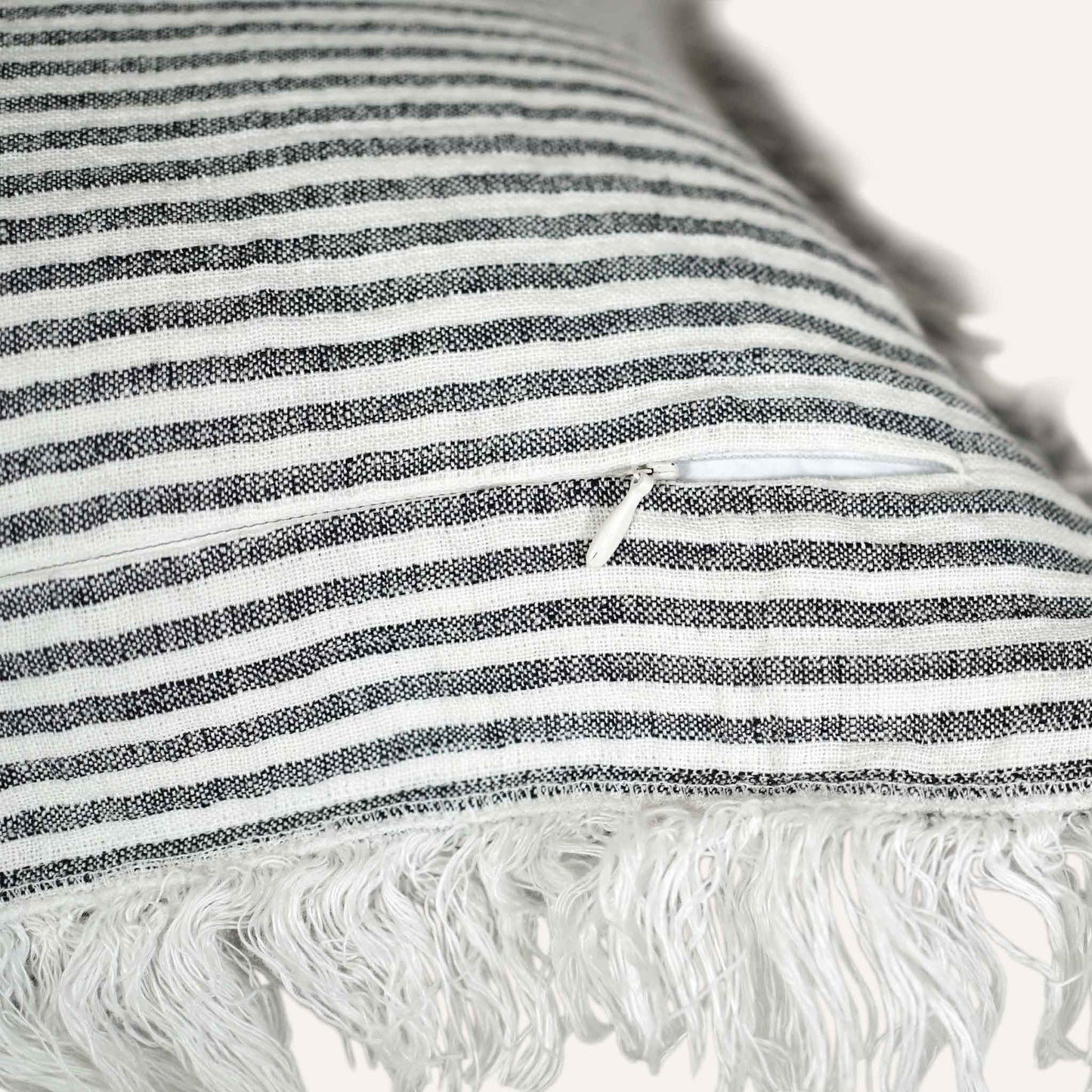 Close-up of the invisible zip on the black and white striped cushion.