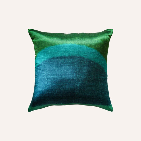 The decorative cushion features a vibrant green and blue tie-dye design in a silk silky material.