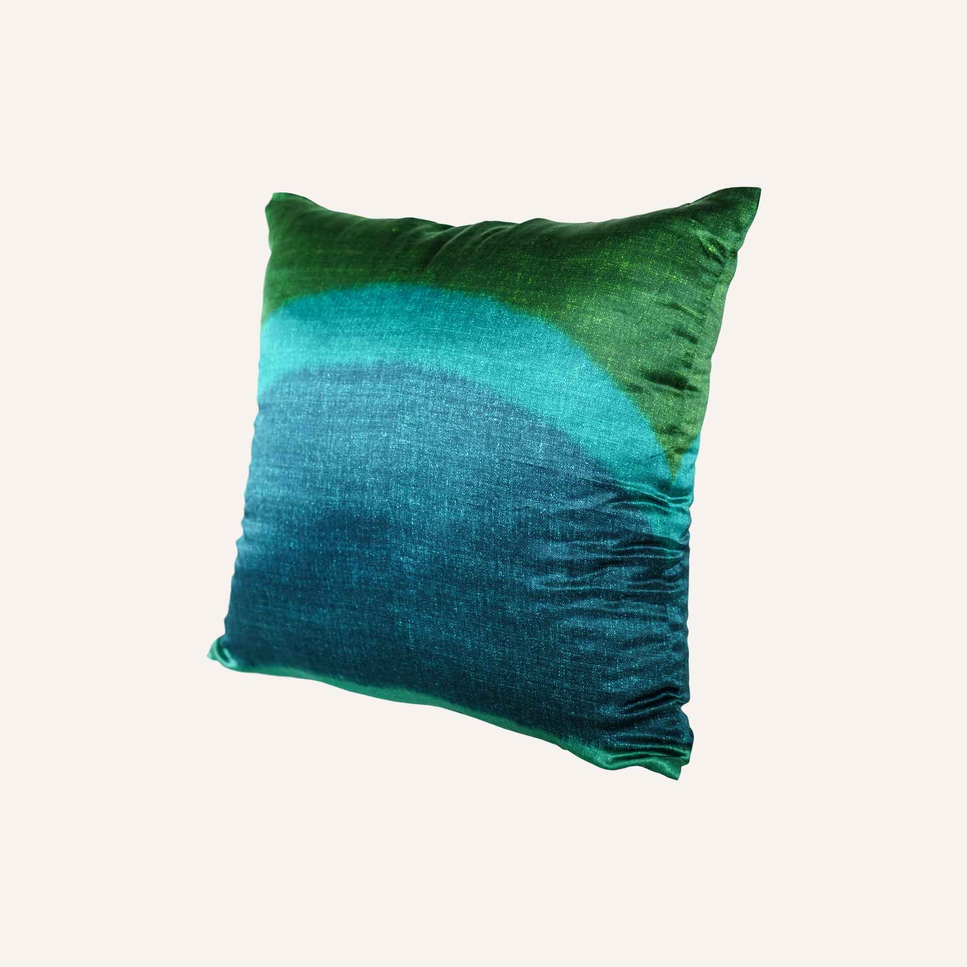 The decorative cushion features a vibrant green and blue tie-dye design in a silk silky material.