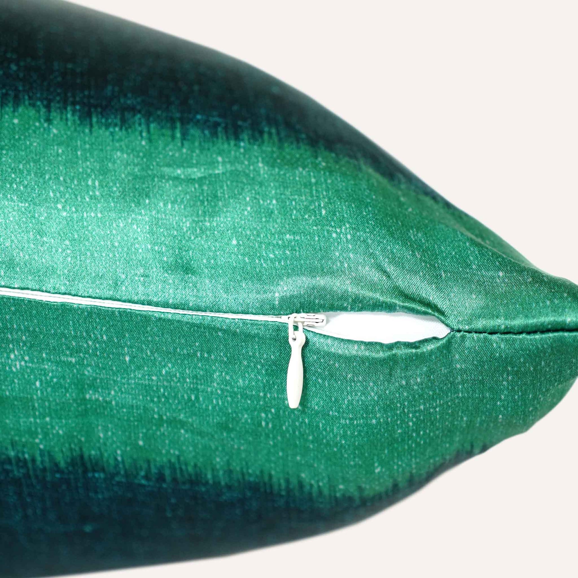 Close-up of the zip on the green and blue cushion.