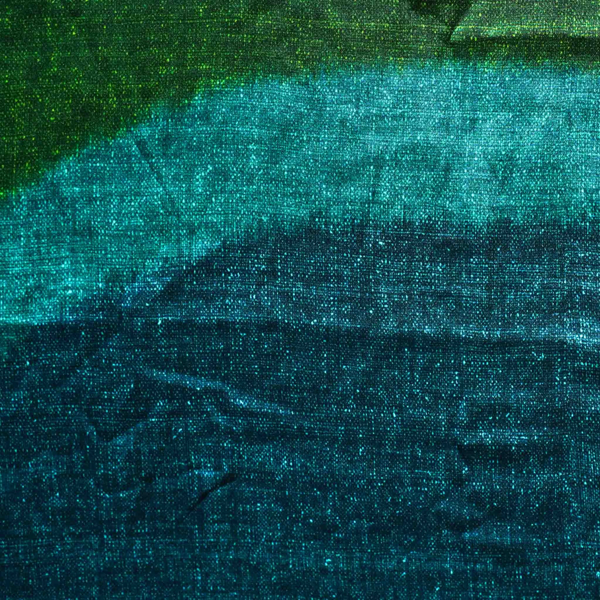 The decorative cushion features a vibrant green and blue tie-dye design in a silk silky material.