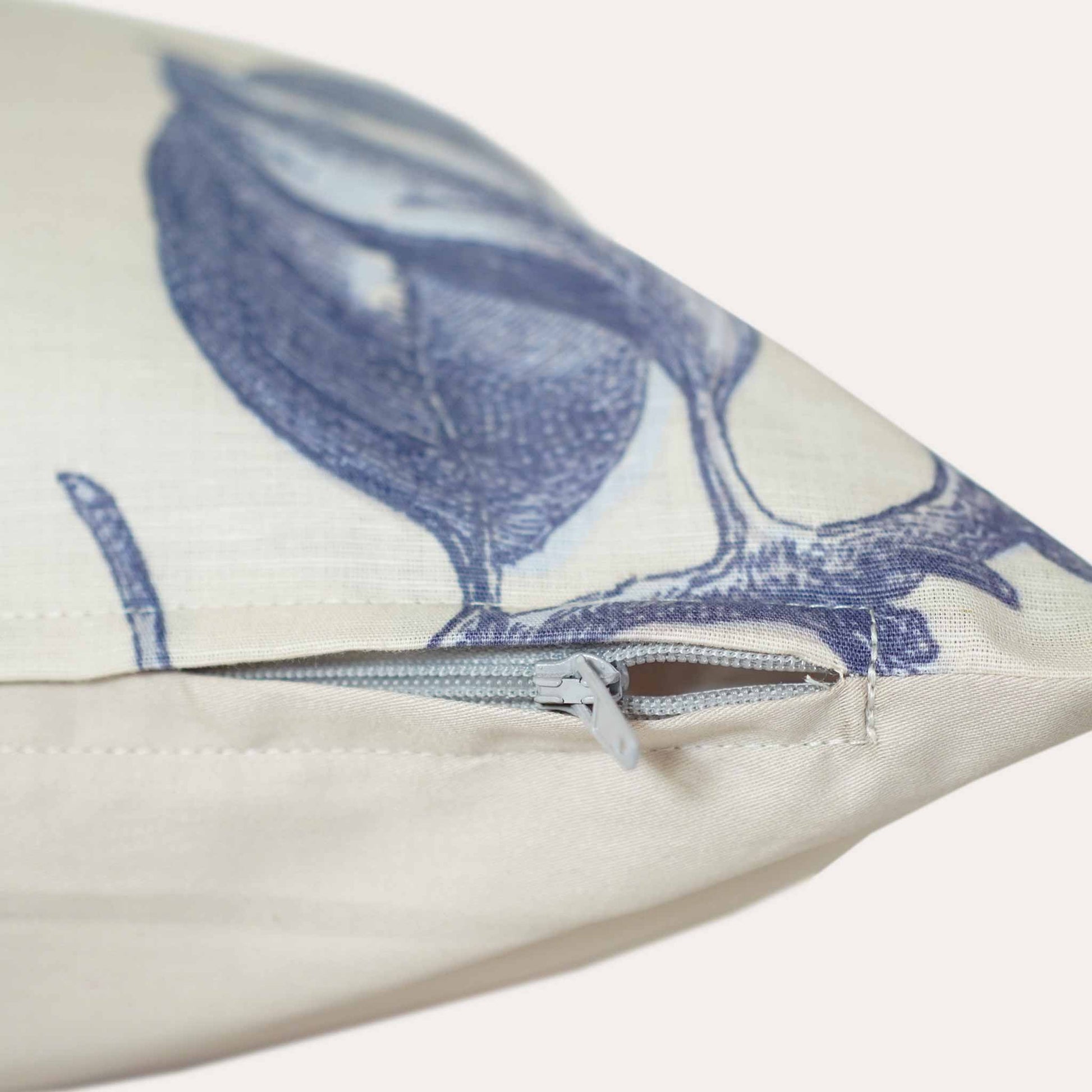 Close up of the invisible zip on the blue printed flower and birds beige bottom lumbar cushion.