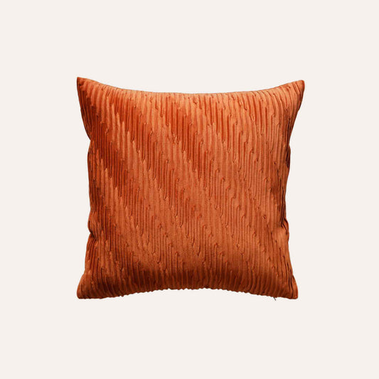 Velvet pumpkin orange cushion covers with pleated design and smooth texture.