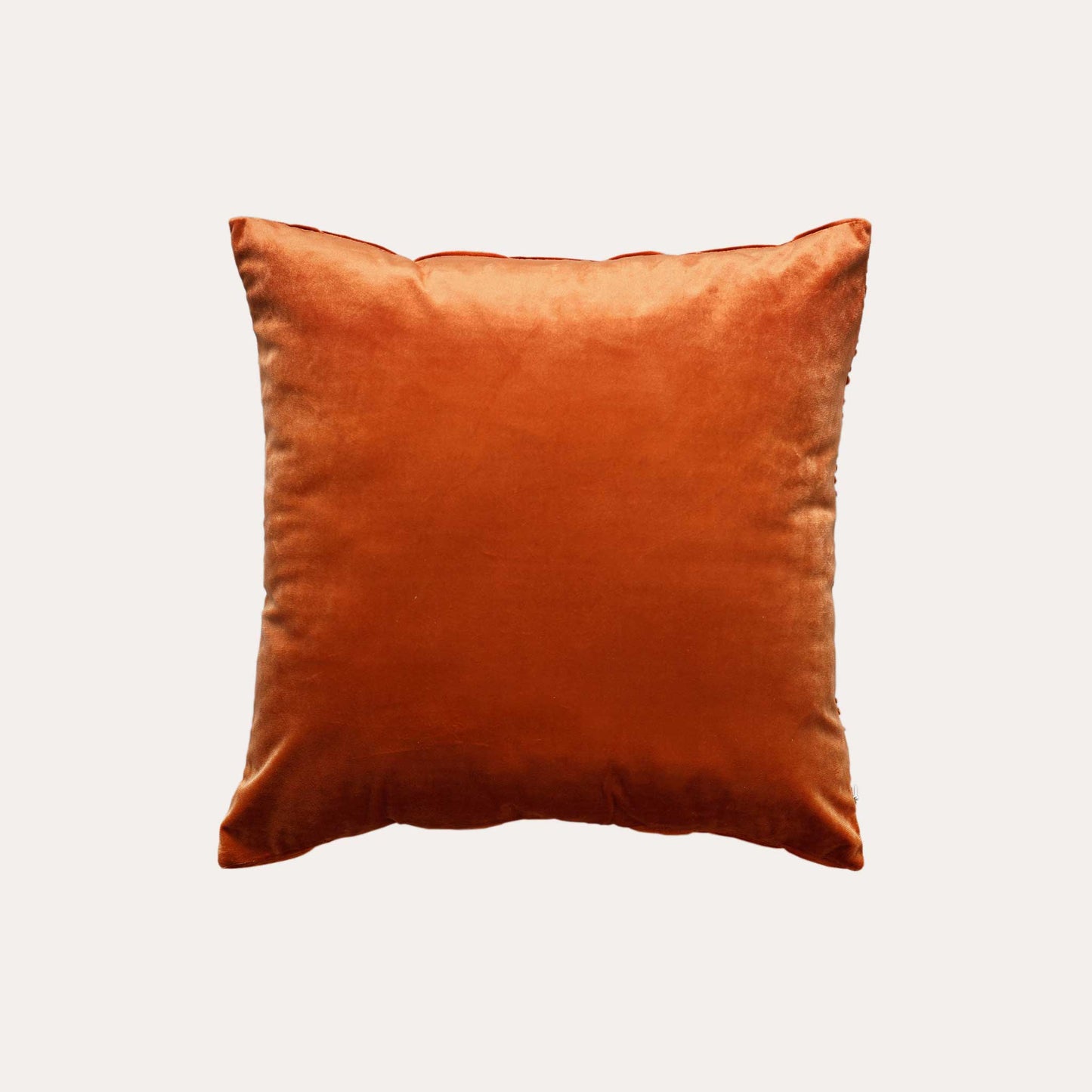 Velvet pumpkin orange cushion covers with pleated design and smooth texture with solid orange back.