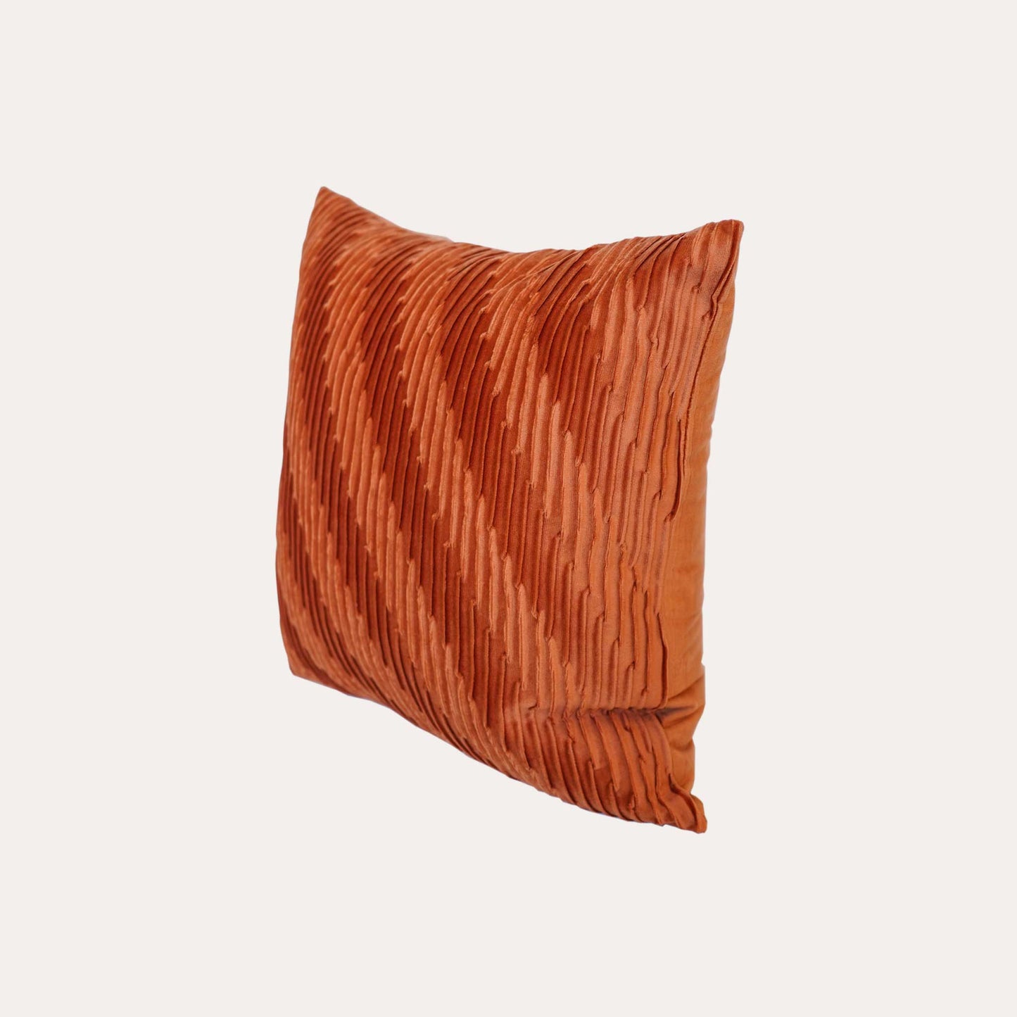 Velvet pumpkin orange cushion covers with pleated design and smooth texture.
