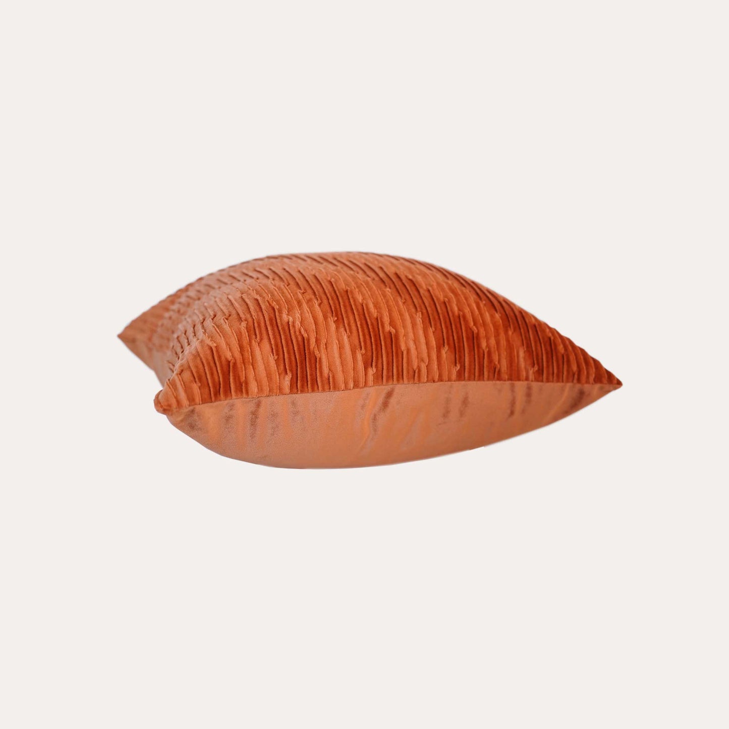 Velvet pumpkin orange cushion covers with pleated design and smooth texture.