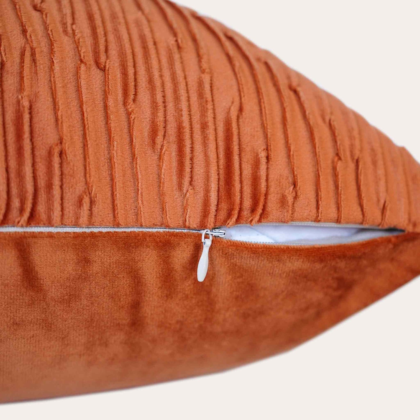 Velvet pumpkin orange cushion covers with pleated design and smooth texture with invisible zipper.