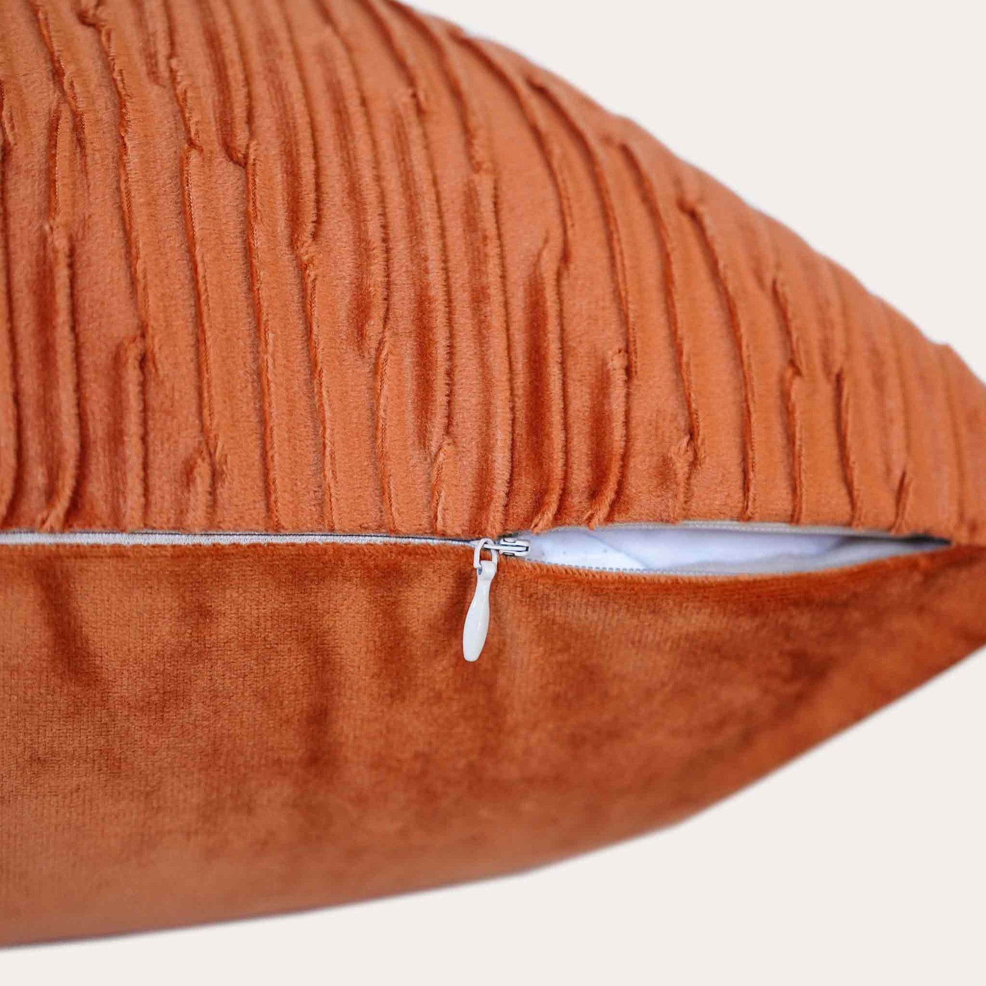 Velvet pumpkin orange cushion covers with pleated design and smooth texture with invisible zipper.