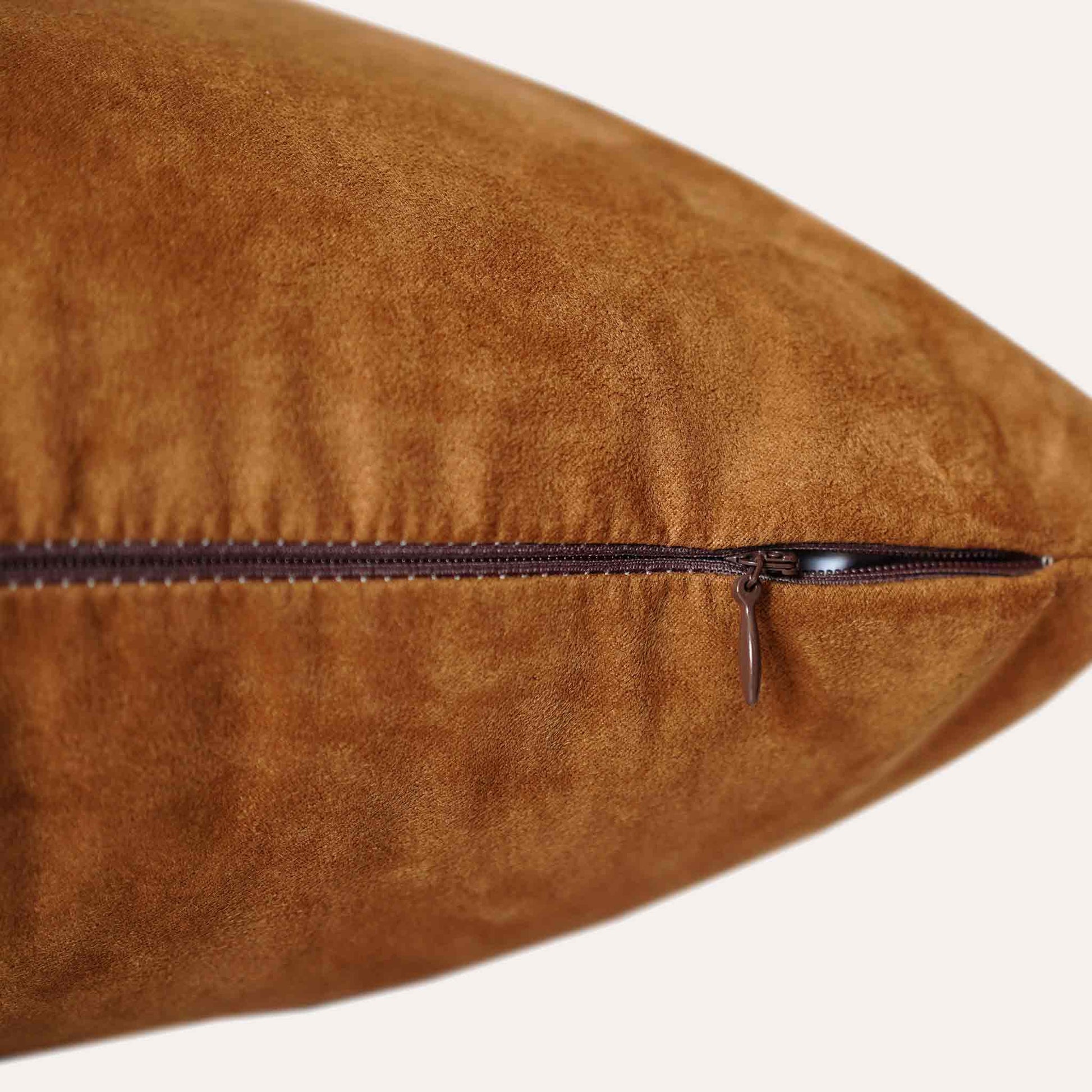 Soft texture and stylish design of solid tan suede cushion cover with invisible zipper.