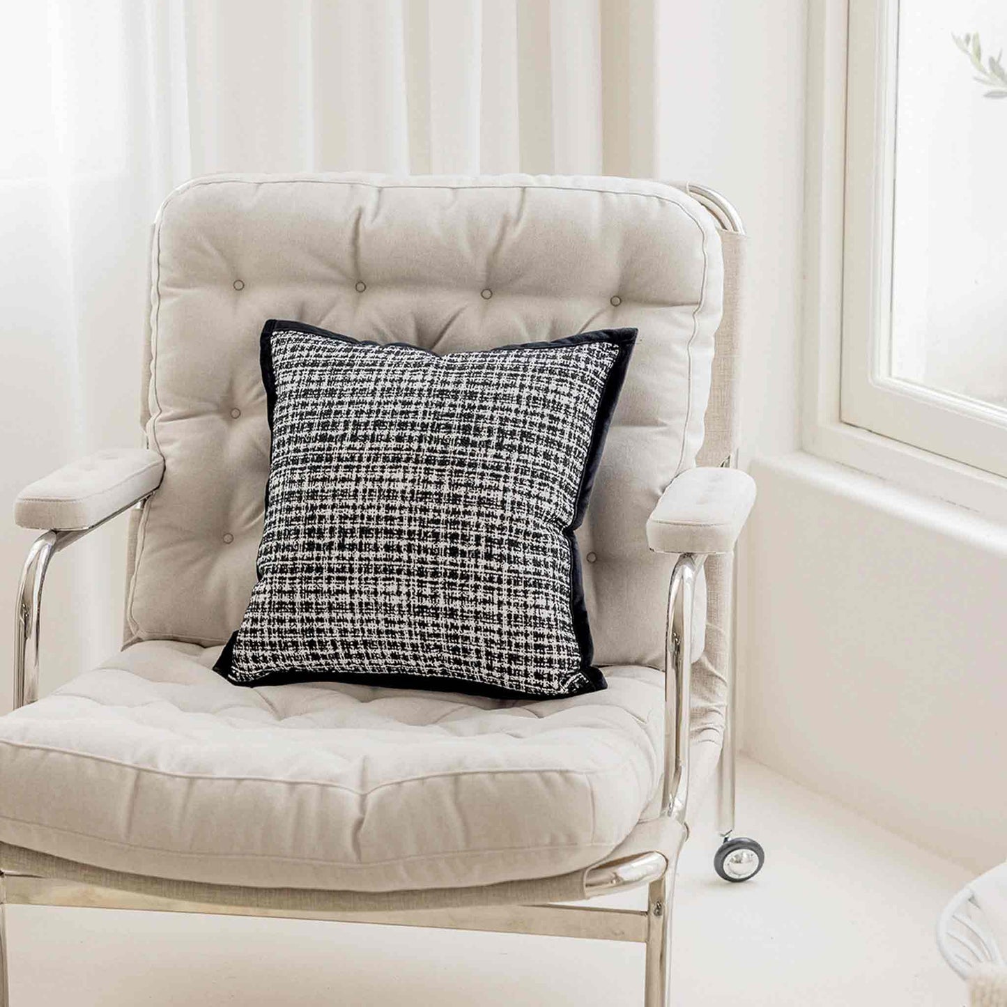 Classic black and white weave textured checkered tweed chenille decor cushion on chair.
