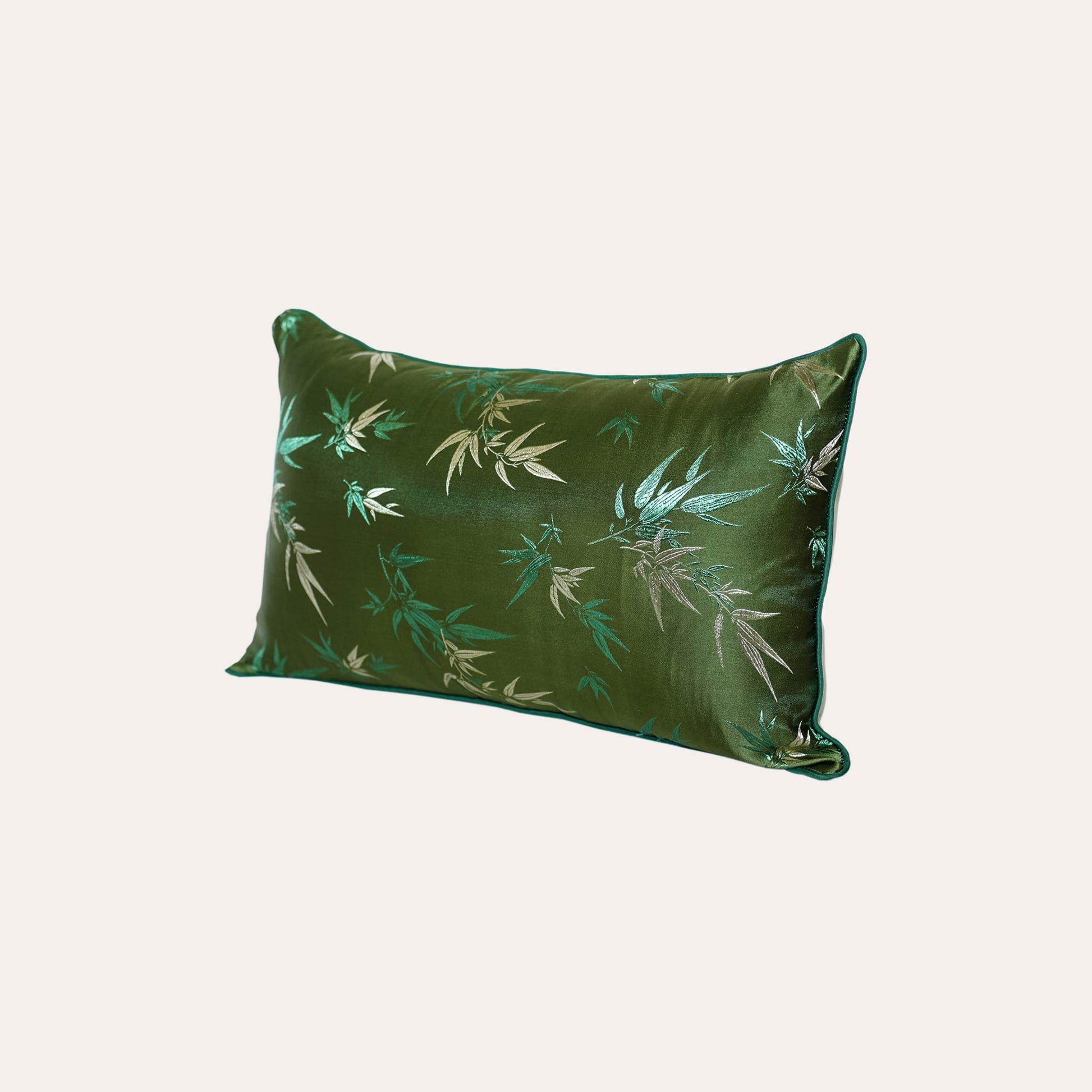 Decorative green cushion cover adorned with golden bamboo leaf design.