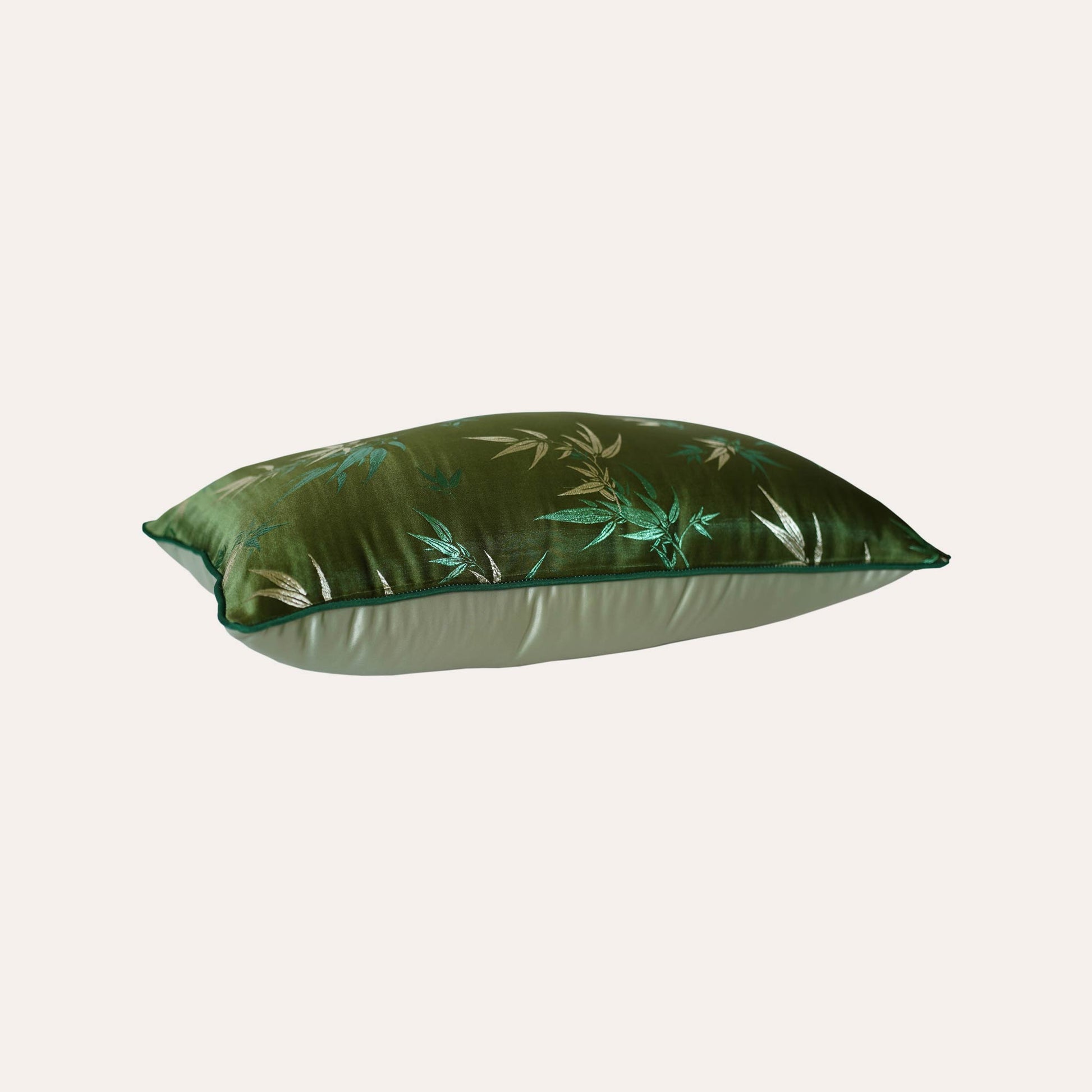 Decorative green cushion cover adorned with golden bamboo leaf design.