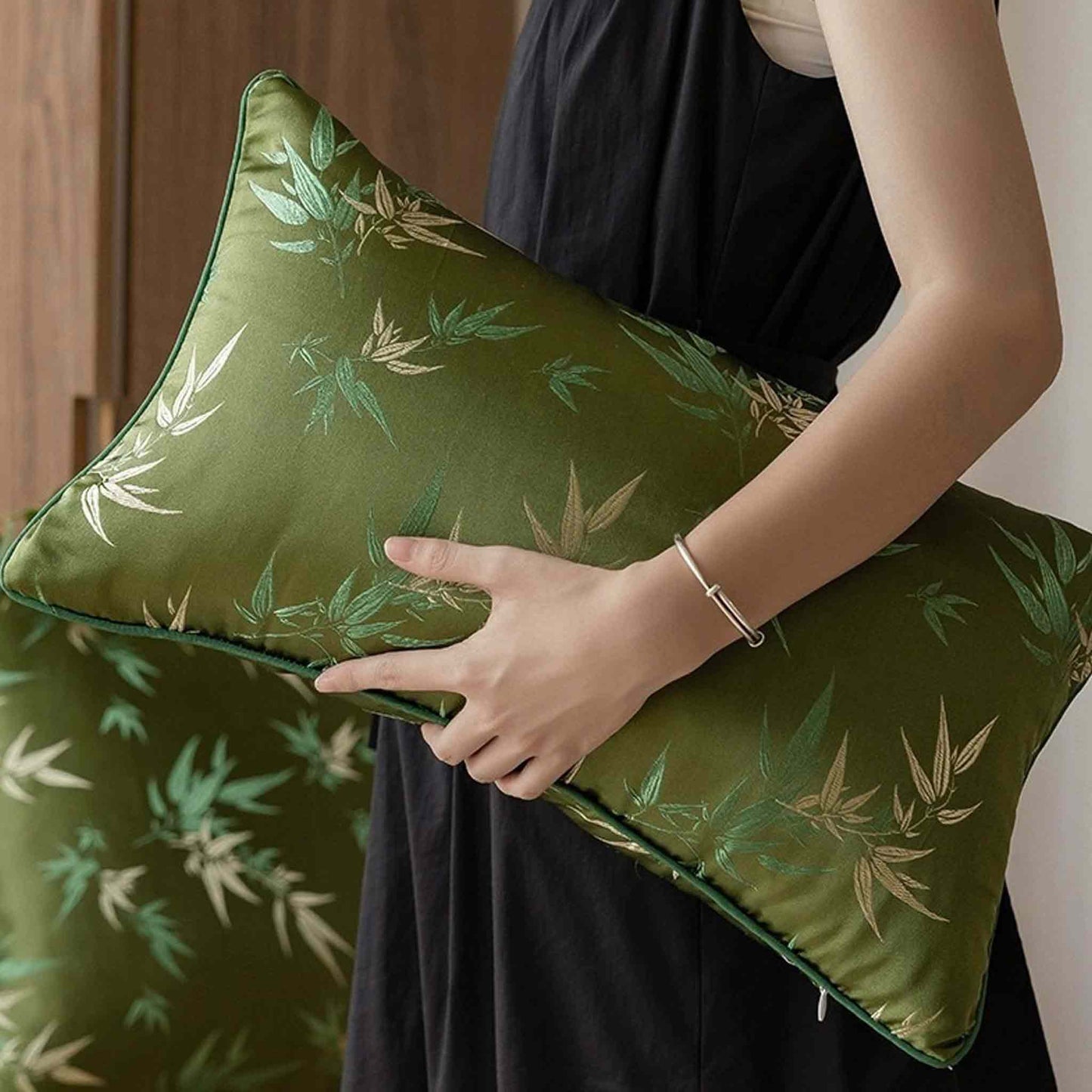 Decorative green cushion cover with gold bamboo leaf pattern embroidery on the fabric
