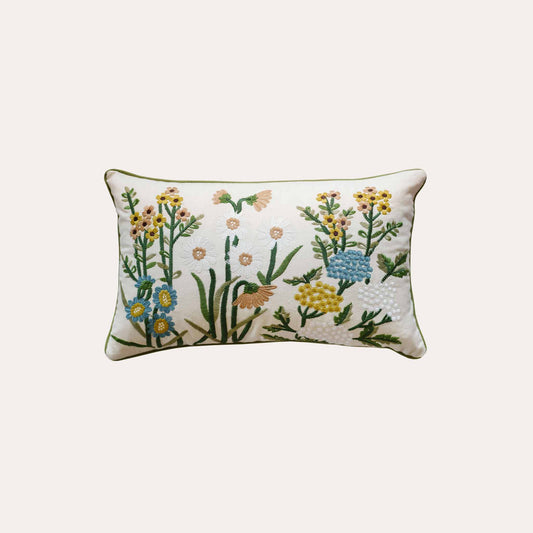 Decorative cushion cover with colorful embroidered floral pattern on a white background.