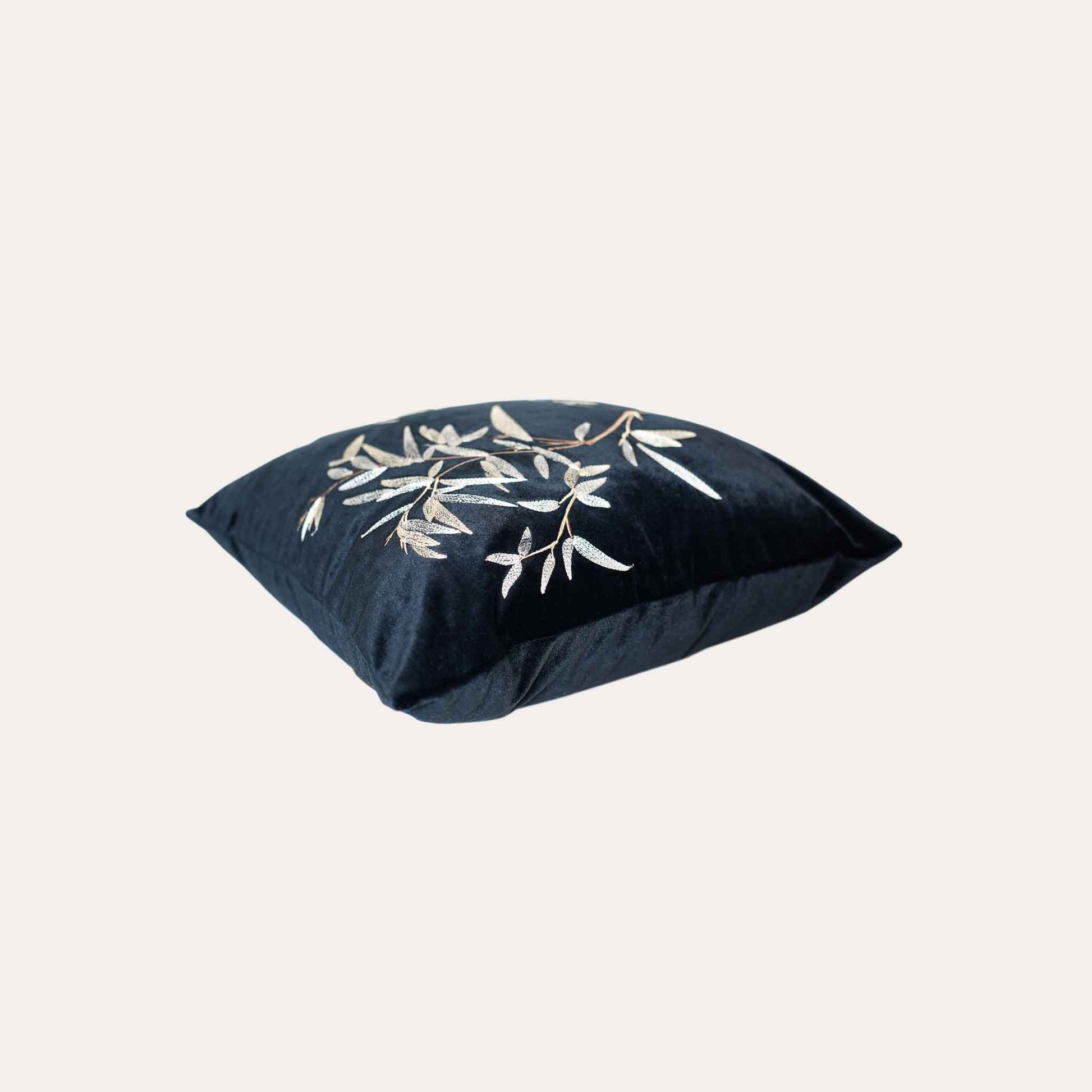 Elegant gold bamboo embroidered cushion cover with black background.