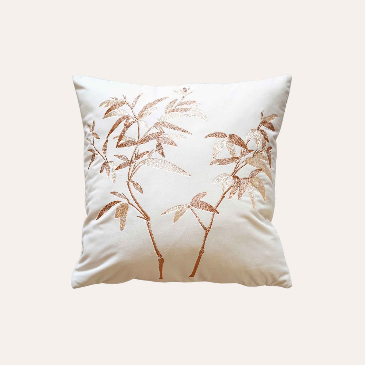 Elegant gold bamboo embroidered cushion cover with white background.