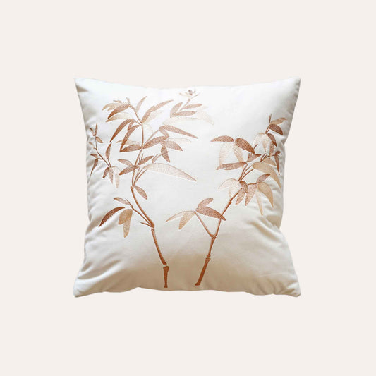 Elegant gold bamboo embroidered cushion cover with white background.