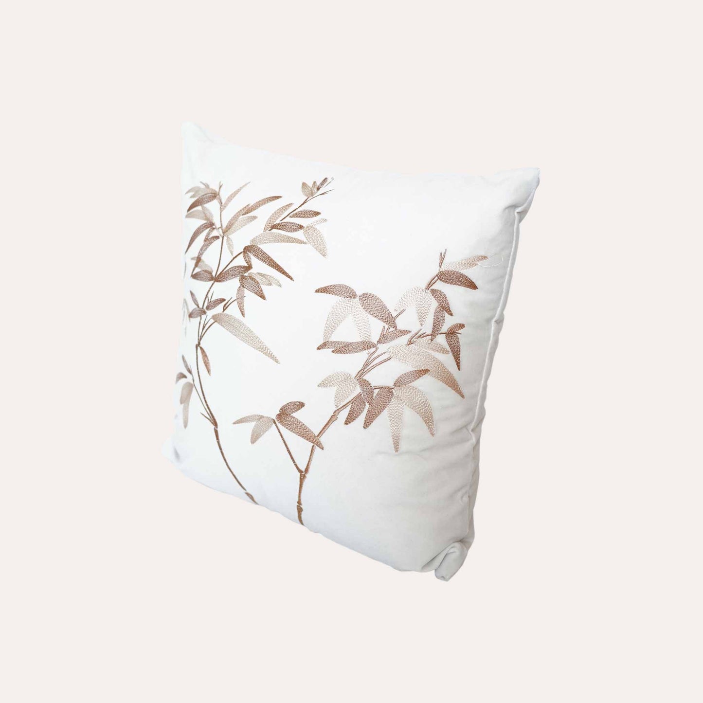 Elegant gold bamboo embroidered cushion cover with white background.