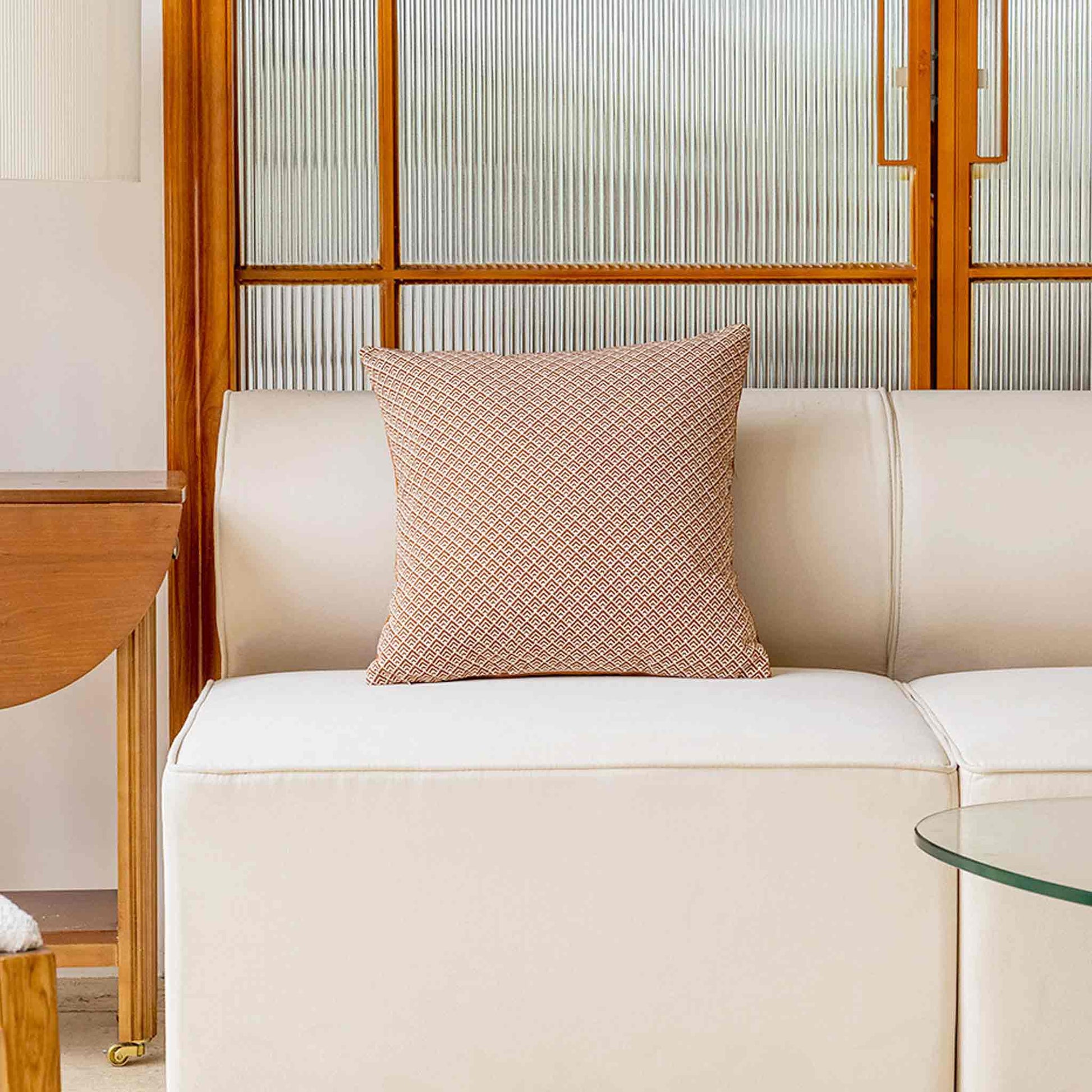 Geometric design cushion covers in red and white chenille on white sofa.