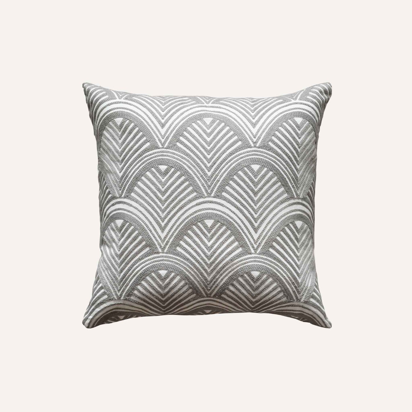 The grey and white scalloped embroidery patterned cushion shows off decorative design and texture.