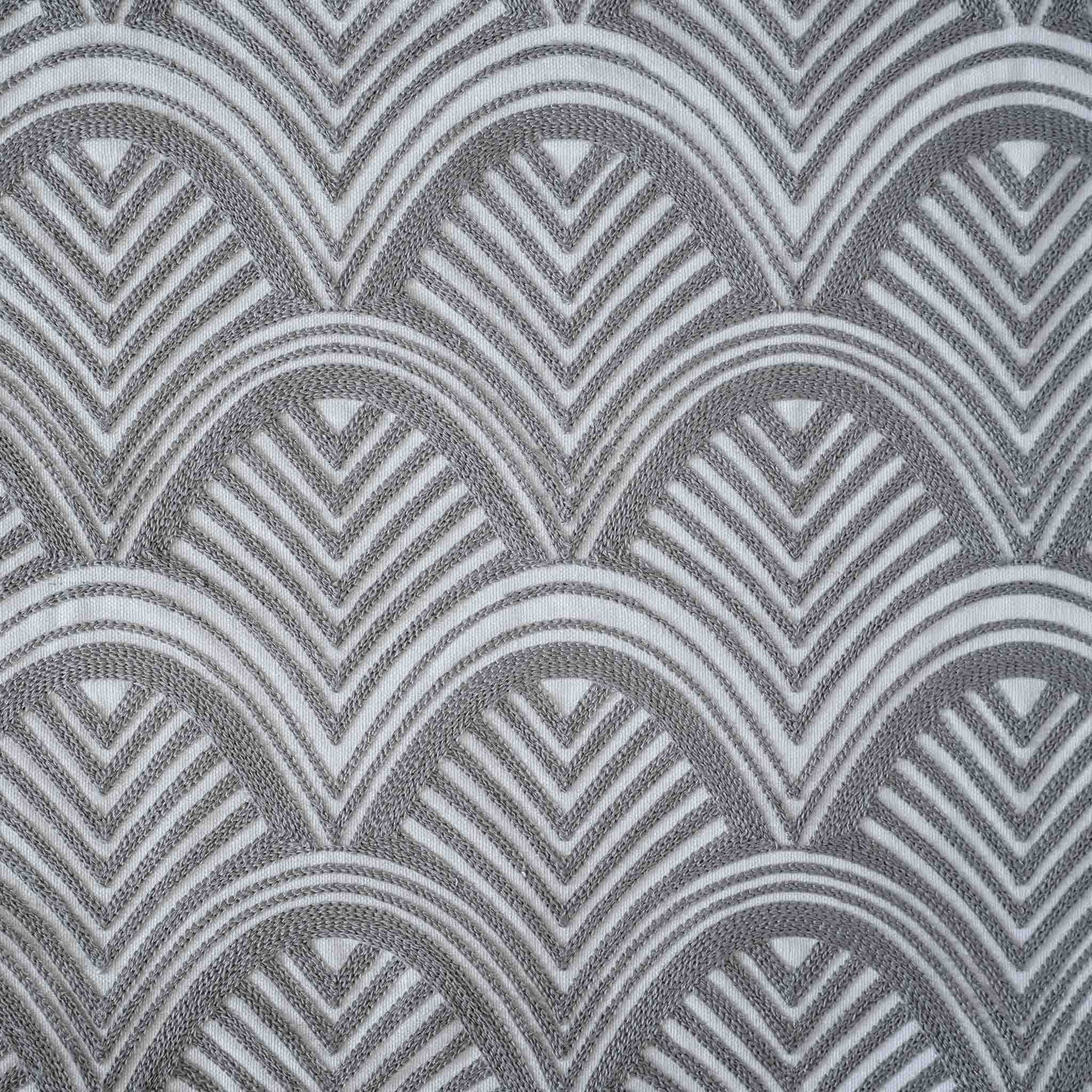 The grey and white scalloped embroidery patterned cushion shows off decorative design and texture.