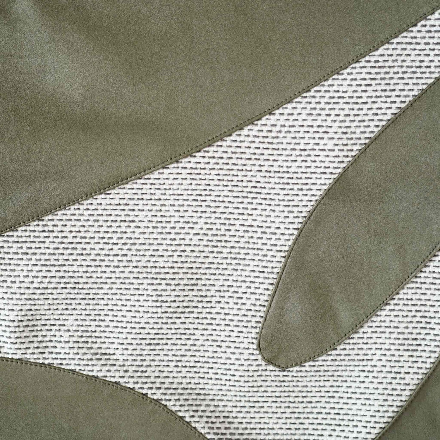 A decorative cushion cover featuring a green and grey irregular splicing design.