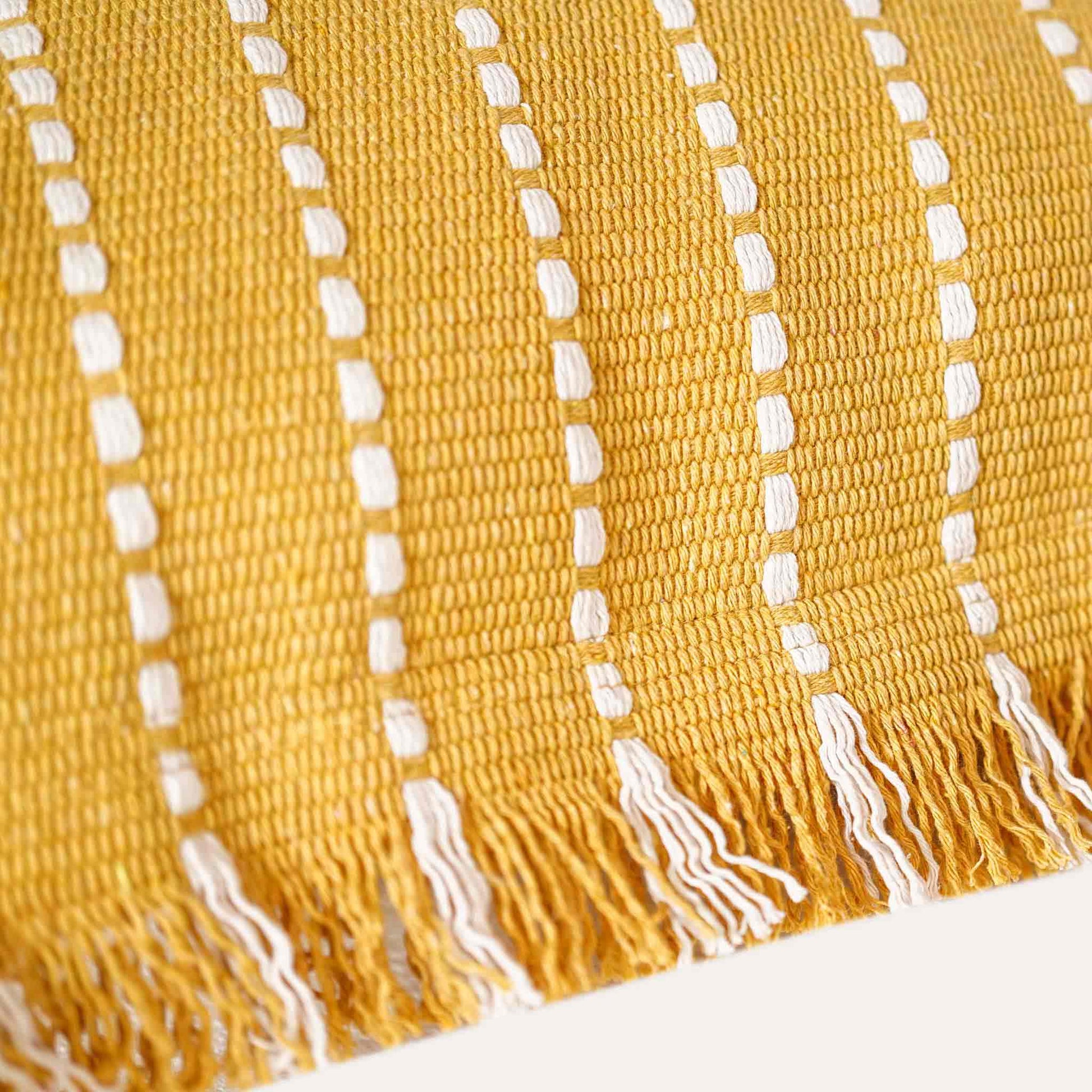 Stylish yellow woven square cushion covers with boho tassels.