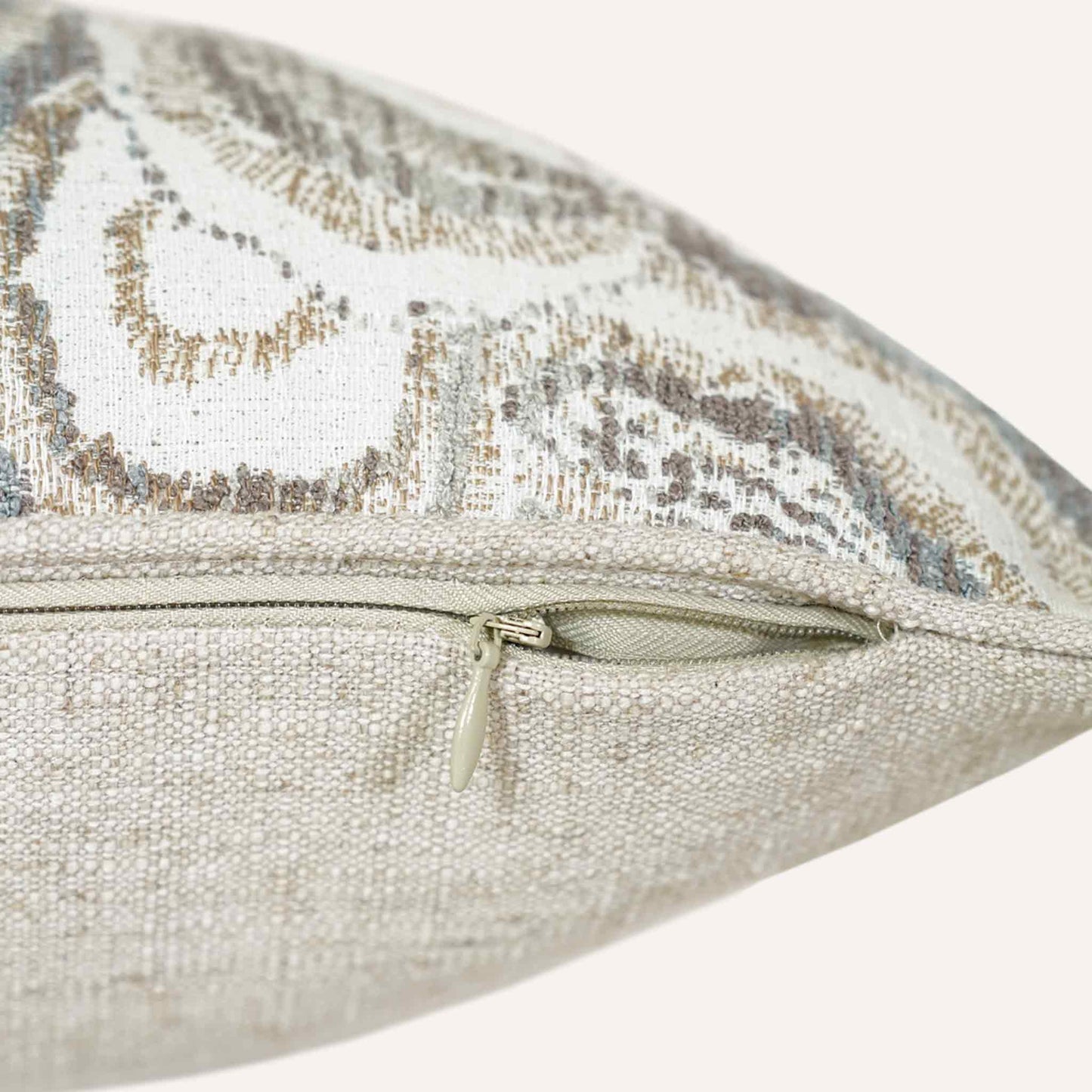 Close-up of the invisible zip on the mother-of-pearl patterned lumbar cushion.