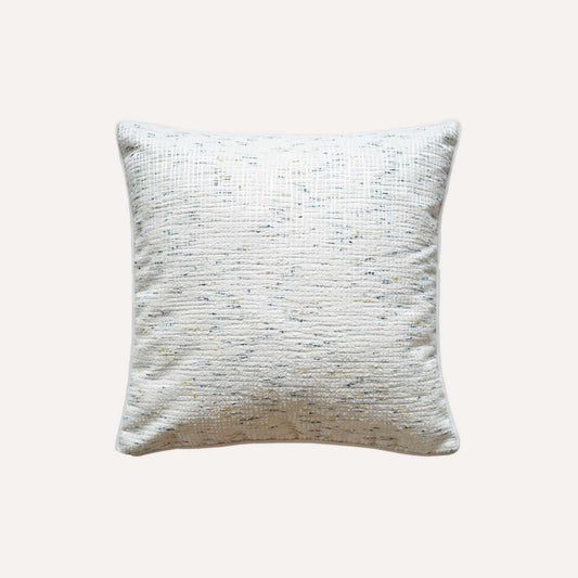 An ivory base cushion cover decorated with blue and yellow colored dots.