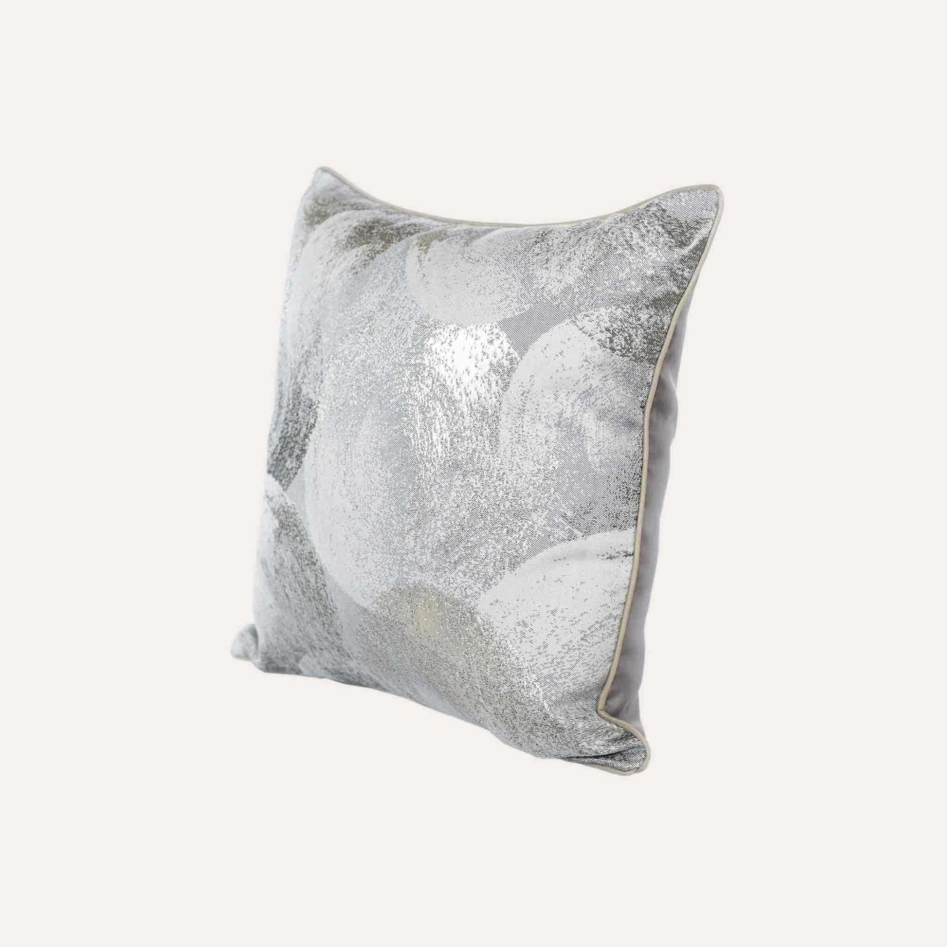A luxurious silver and grey jacquard cushion cover featuring an abstract design.