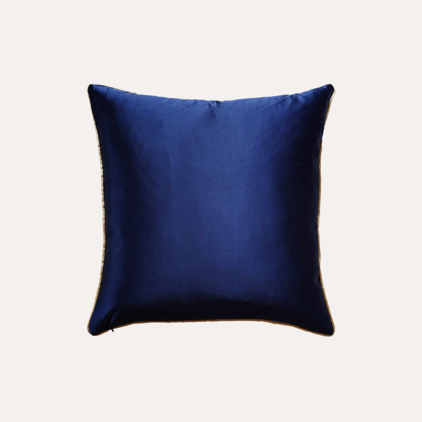 A cushion cover featuring a navy base adorned with delicate gold lines with solid blue back, exuding a sense of luxury.