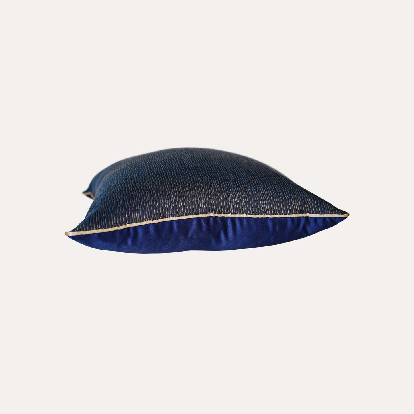A cushion cover featuring a navy base adorned with delicate gold lines, exuding a sense of luxury.