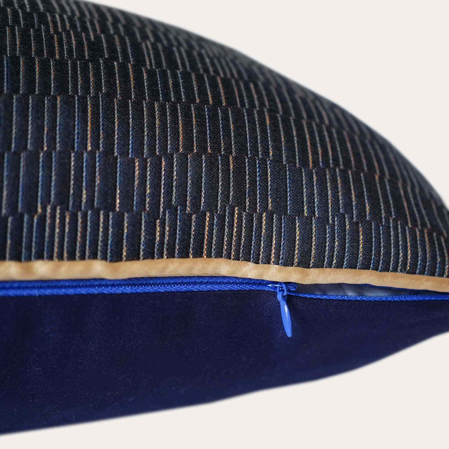 A cushion cover featuring a navy base adorned with delicate gold lines with invisible zipper, exuding a sense of luxury.